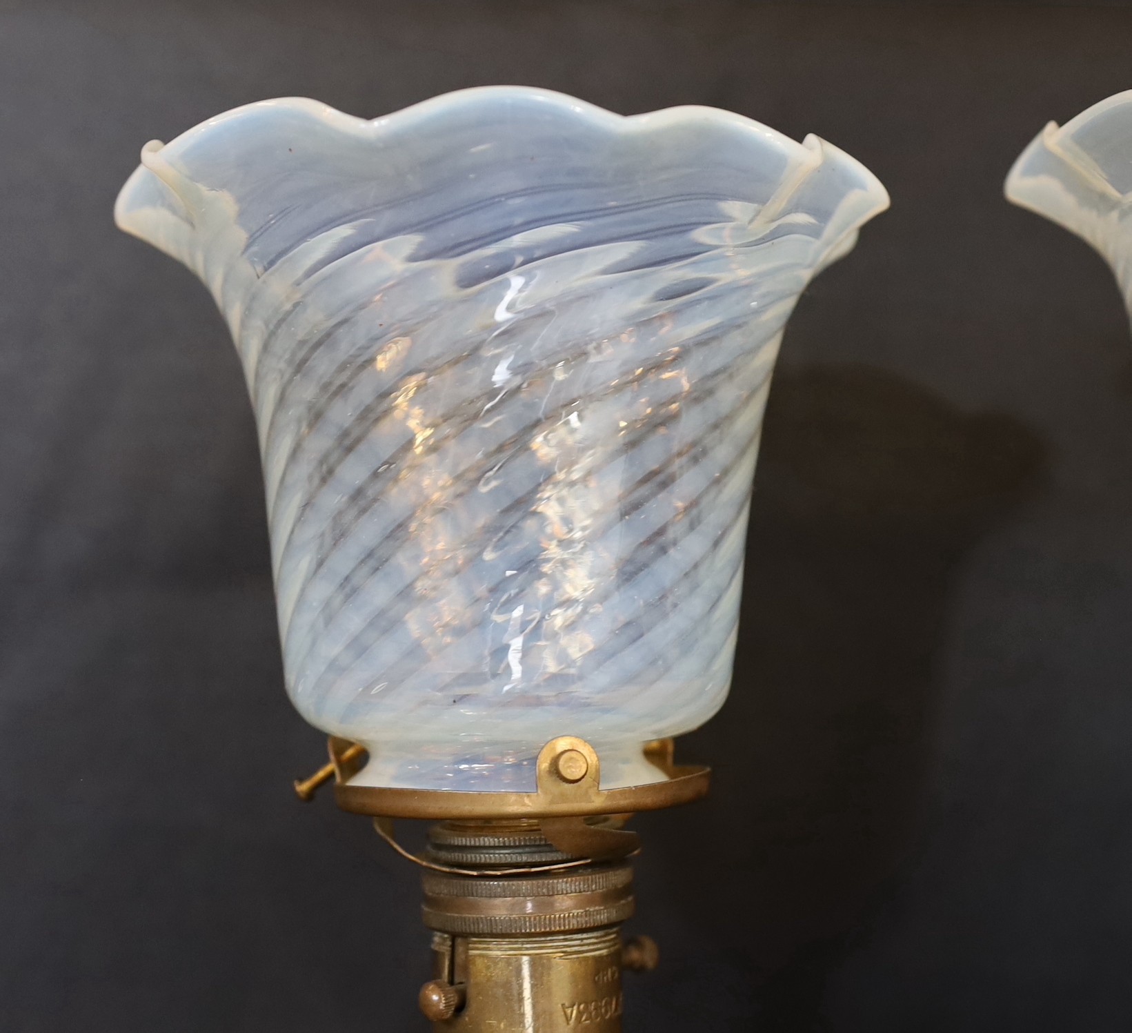 A pair of brass Pullman lamps with gimbal stems and Vaseline glass shades, modelled for wall mounting or freestanding, height to top of shade 40cm